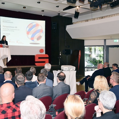 Bild eines gefülltes Saales, in dem über nachhaltiges Wirtschaften diskutiert wird.