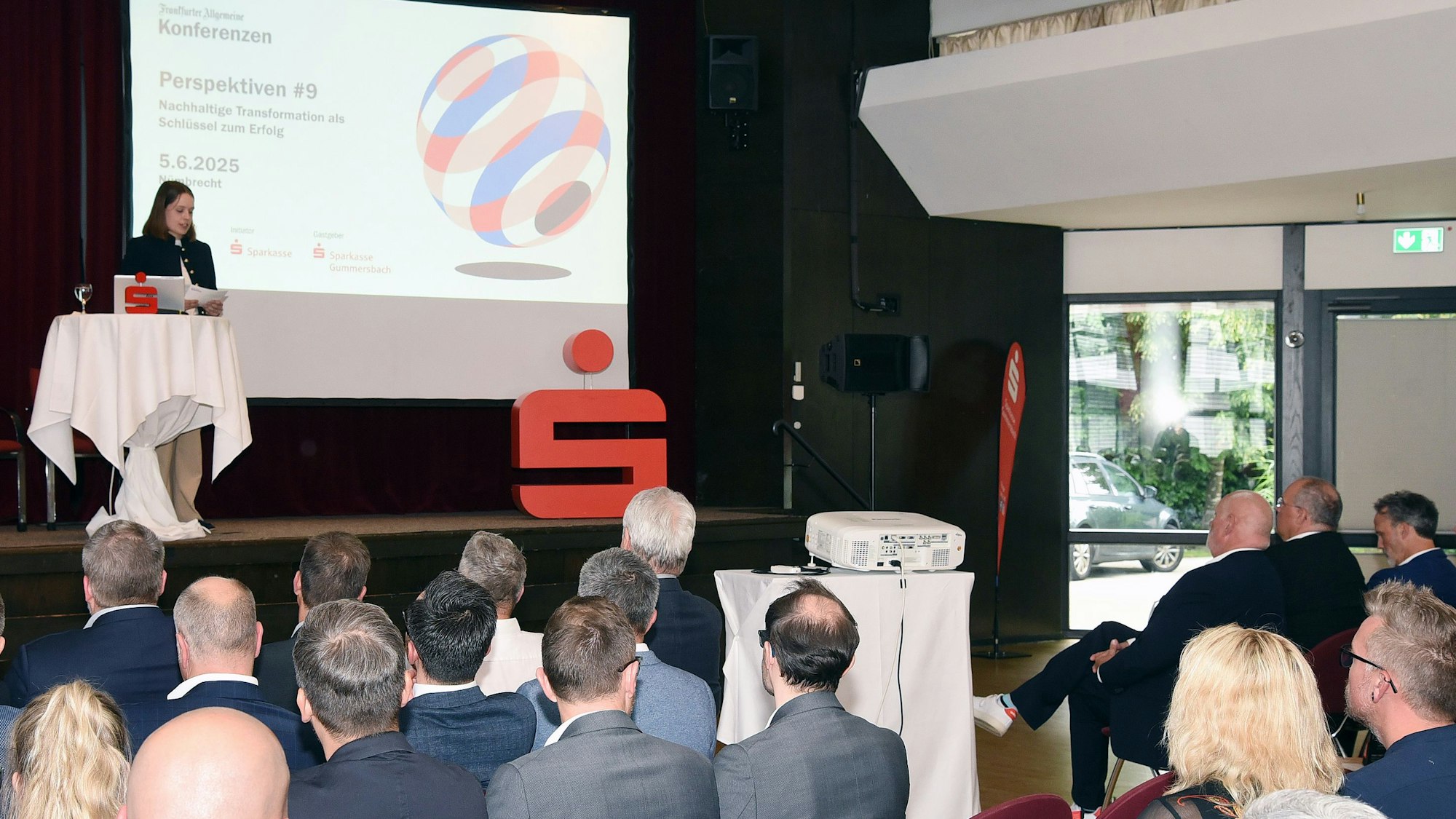 Bild eines gefülltes Saales, in dem über nachhaltiges Wirtschaften diskutiert wird.