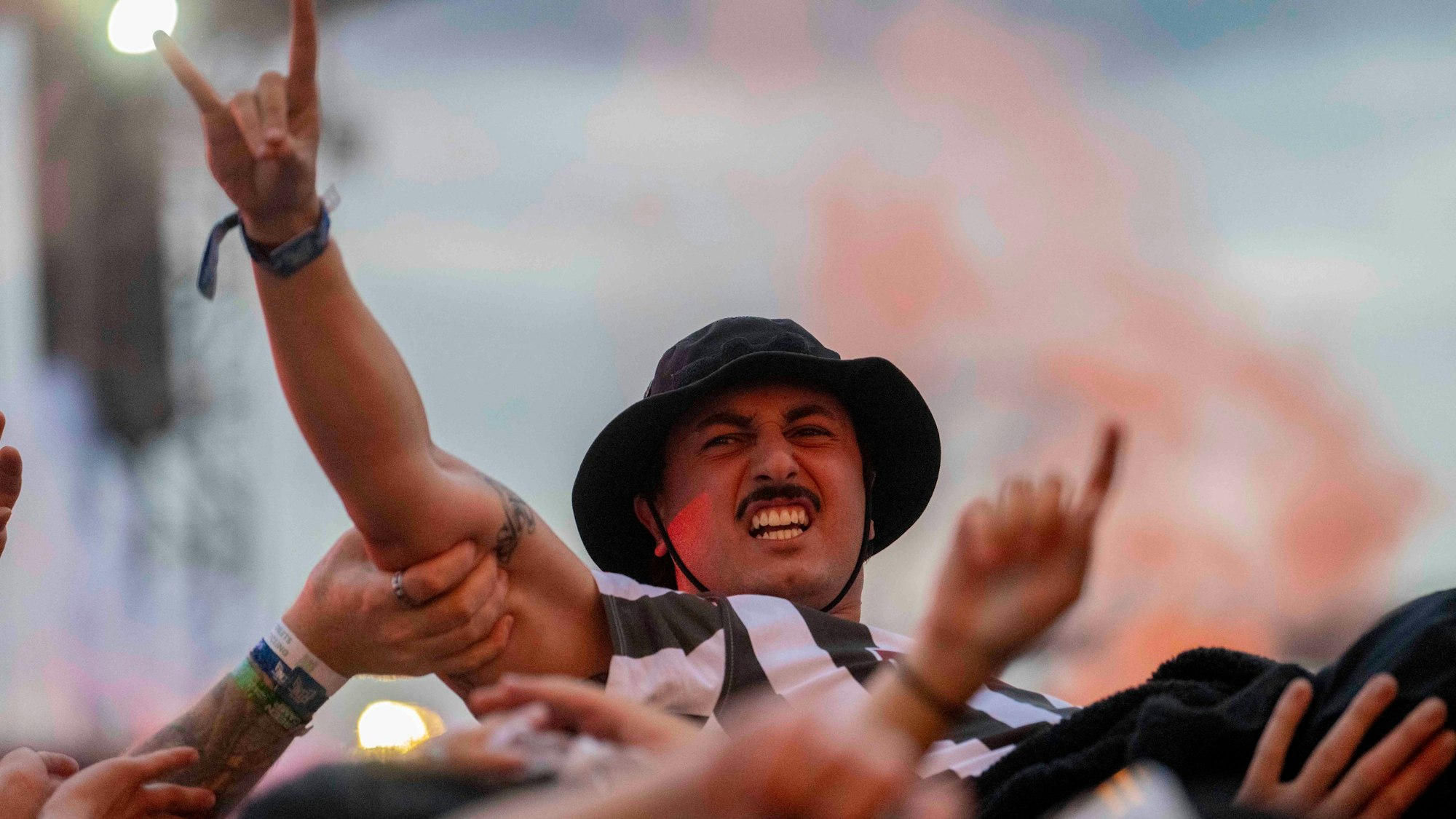 Das Bild zeigt einen Mann, der auf den Händen der Menge surft.