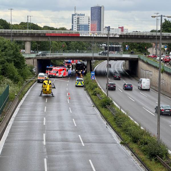 Einsatzkräfte von Polizei, Feuerwehr und Rettungsdienst sind auf einer Autobahn im Einsatz. Ein Hubschrauber ist auf der Fahrbahn gelandet.