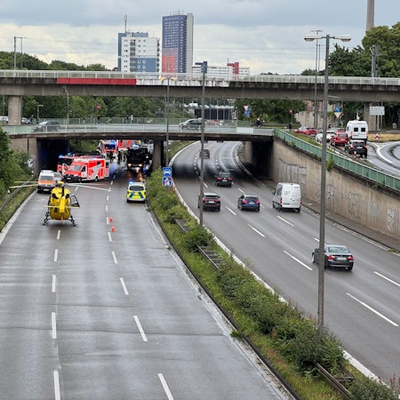 Einsatzkräfte von Polizei, Feuerwehr und Rettungsdienst sind auf einer Autobahn im Einsatz. Ein Hubschrauber ist auf der Fahrbahn gelandet.