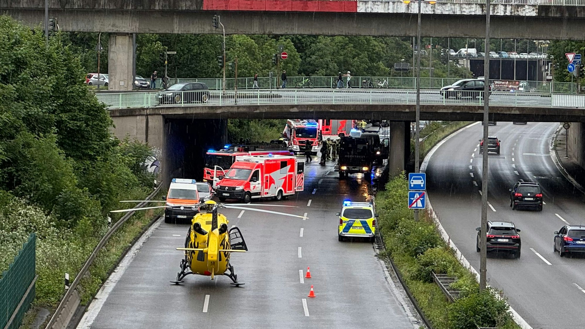 Einsatzkräfte von Polizei, Feuerwehr und Rettungsdienst sind auf einer Autobahn im Einsatz. Ein Hubschrauber ist auf der Fahrbahn gelandet.