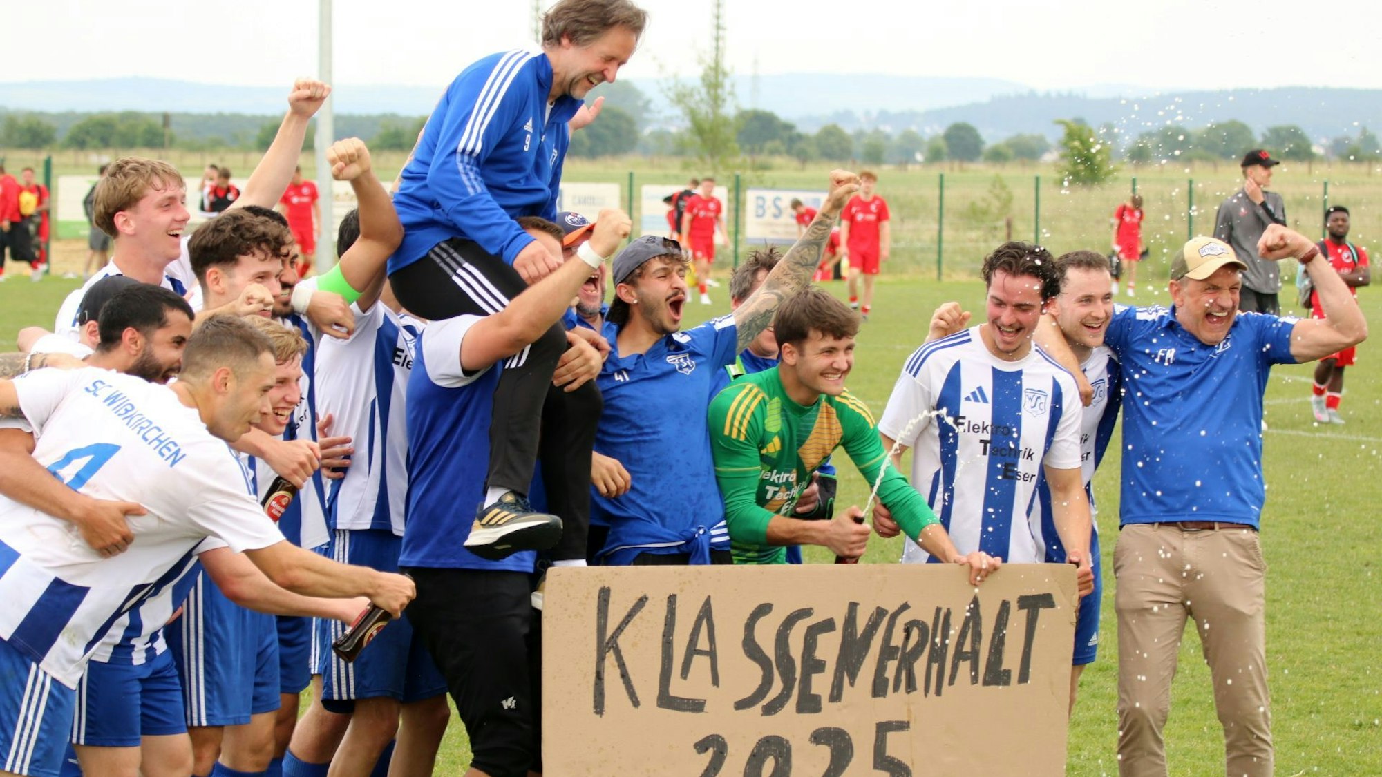 Die Mannschaft jubelt über den Klassenerhalt, Trainer Horst Bartz sitzt auf den Schultern eines Spielers.