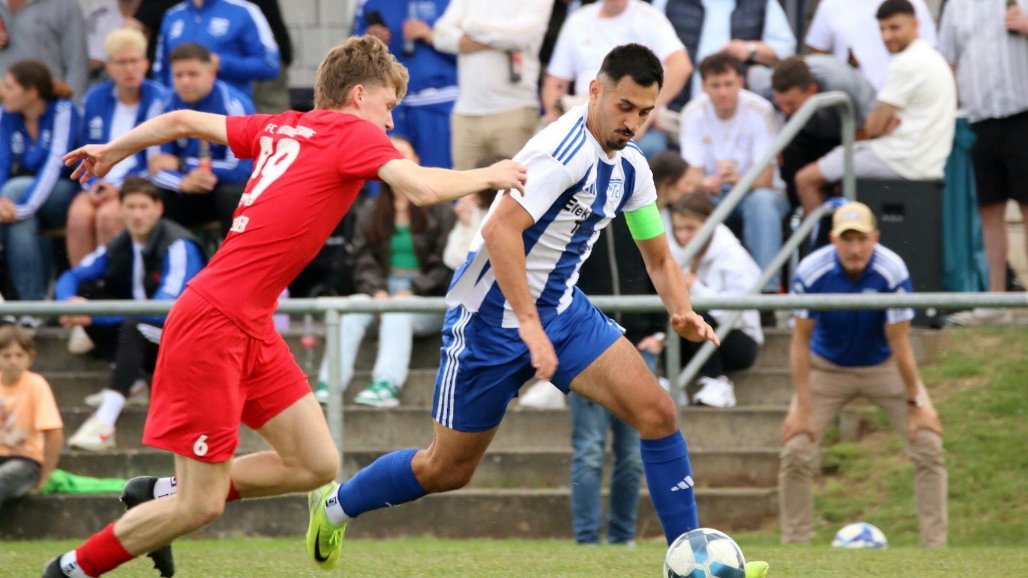 Deniz Isitmen läuft mit dem Ball an einem Gegenspieler vorbei. Im Hintergrund sind die Zuschauer zu sehen.