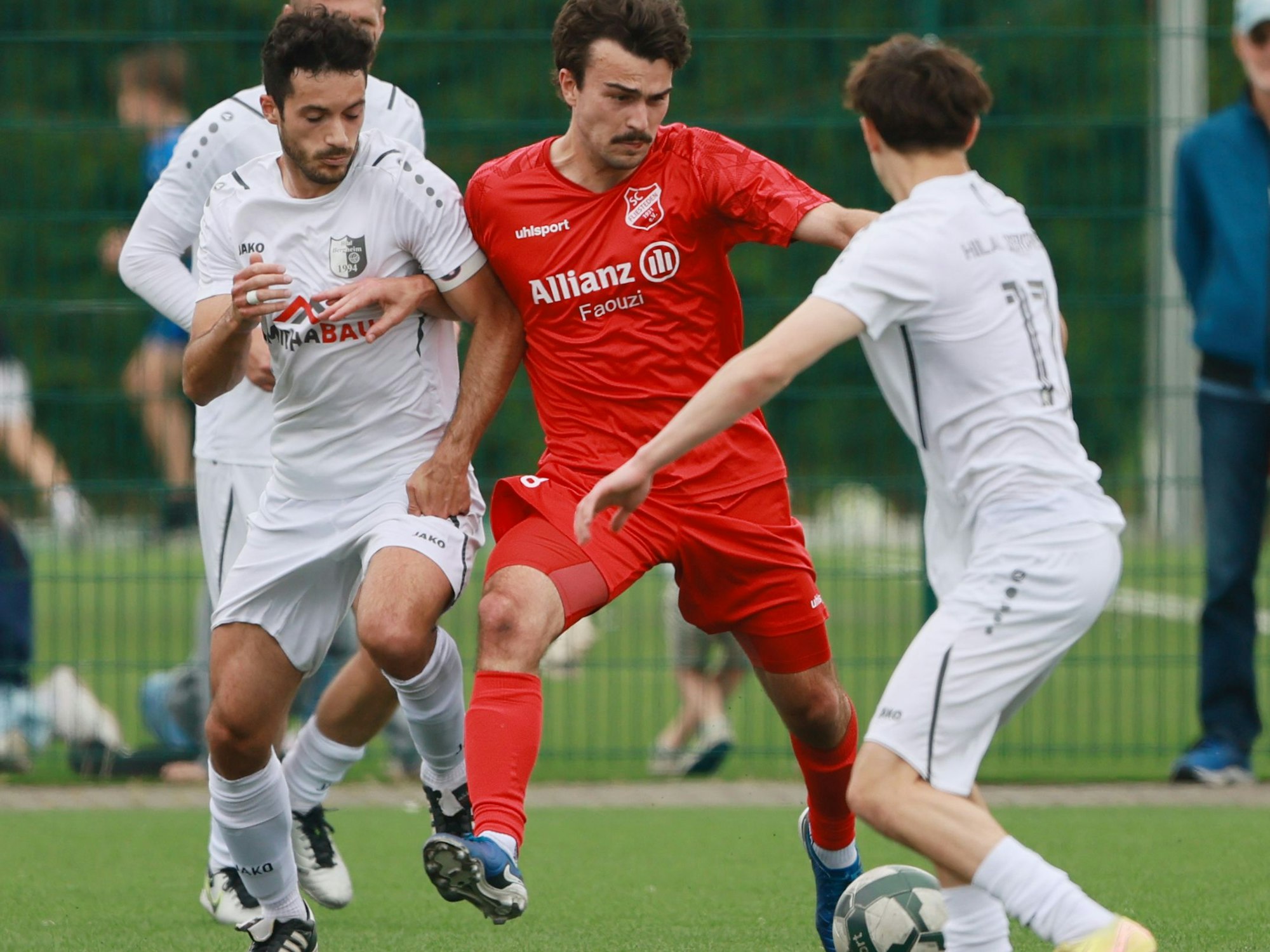 Das Foto zeigt einen Fliestedener Spieler, der von zwei Bergheimer Gegenspielern arg bedrängt wird.