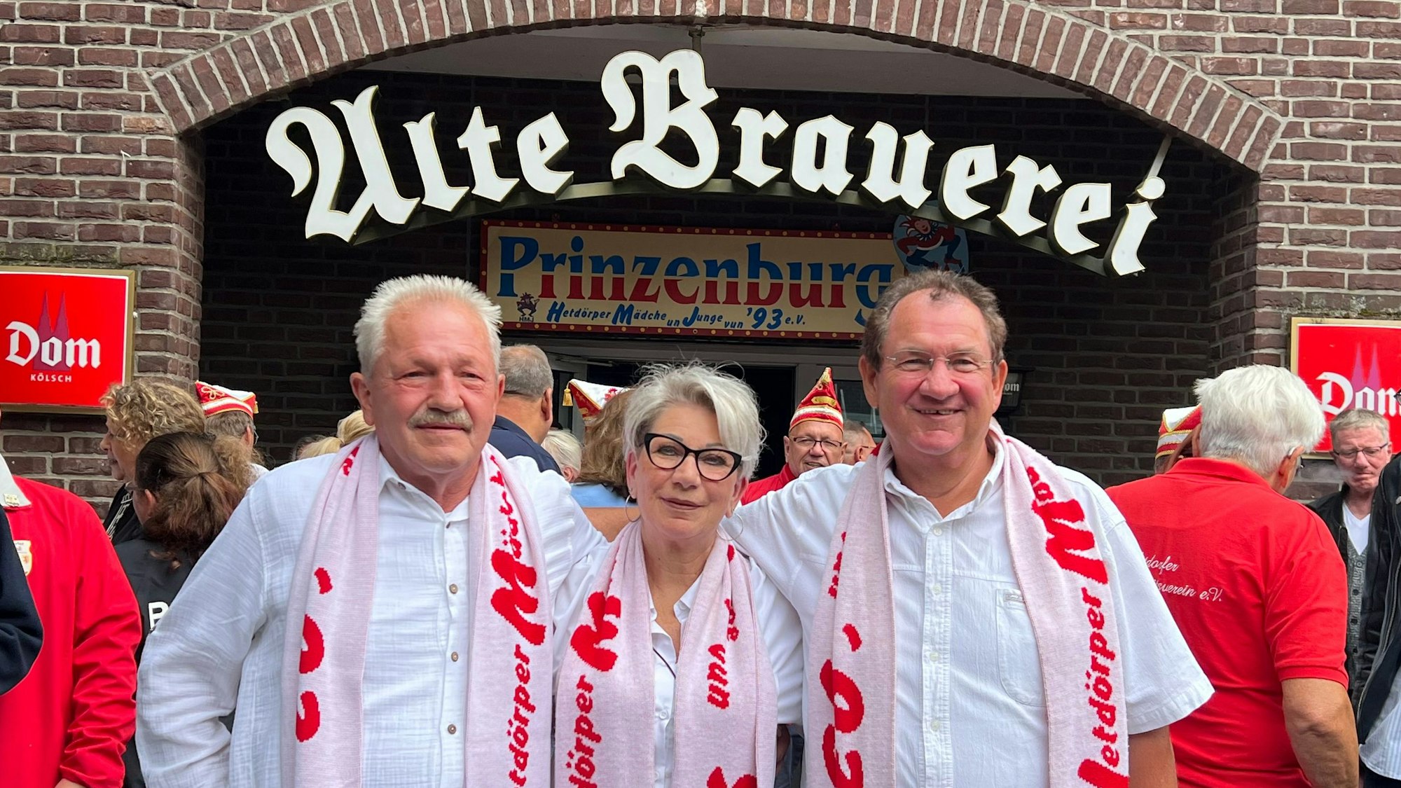 Das Hitdorfer Dreigestirn 2025 /2026 steht vor der Prinzenburg: Bauer De Kölsche Ricci (Reinhard Deichert, links), Jungfrau Rainhilde (Rainer Kruczynski, rechts) Und in der Mitte steht Prinz Heike I.(Heike Corton Vegas).