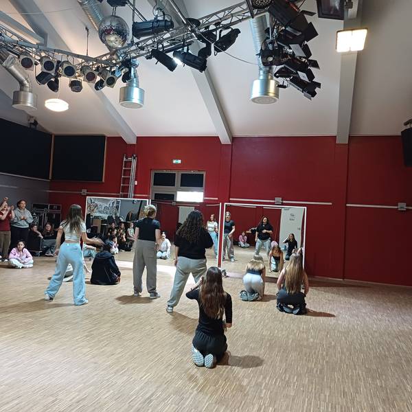 Kinder und Jugendliche bewegen sich in einem Tanzsaal.
