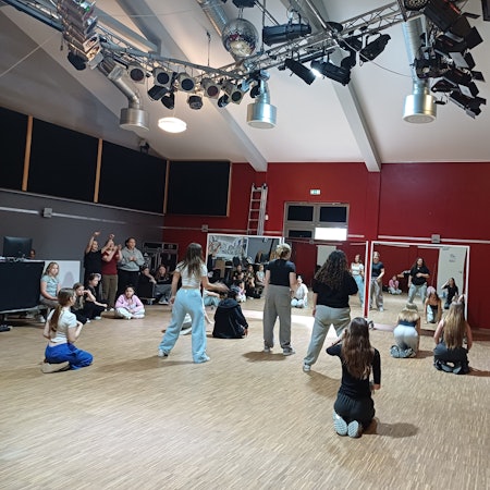 Kinder und Jugendliche bewegen sich in einem Tanzsaal.