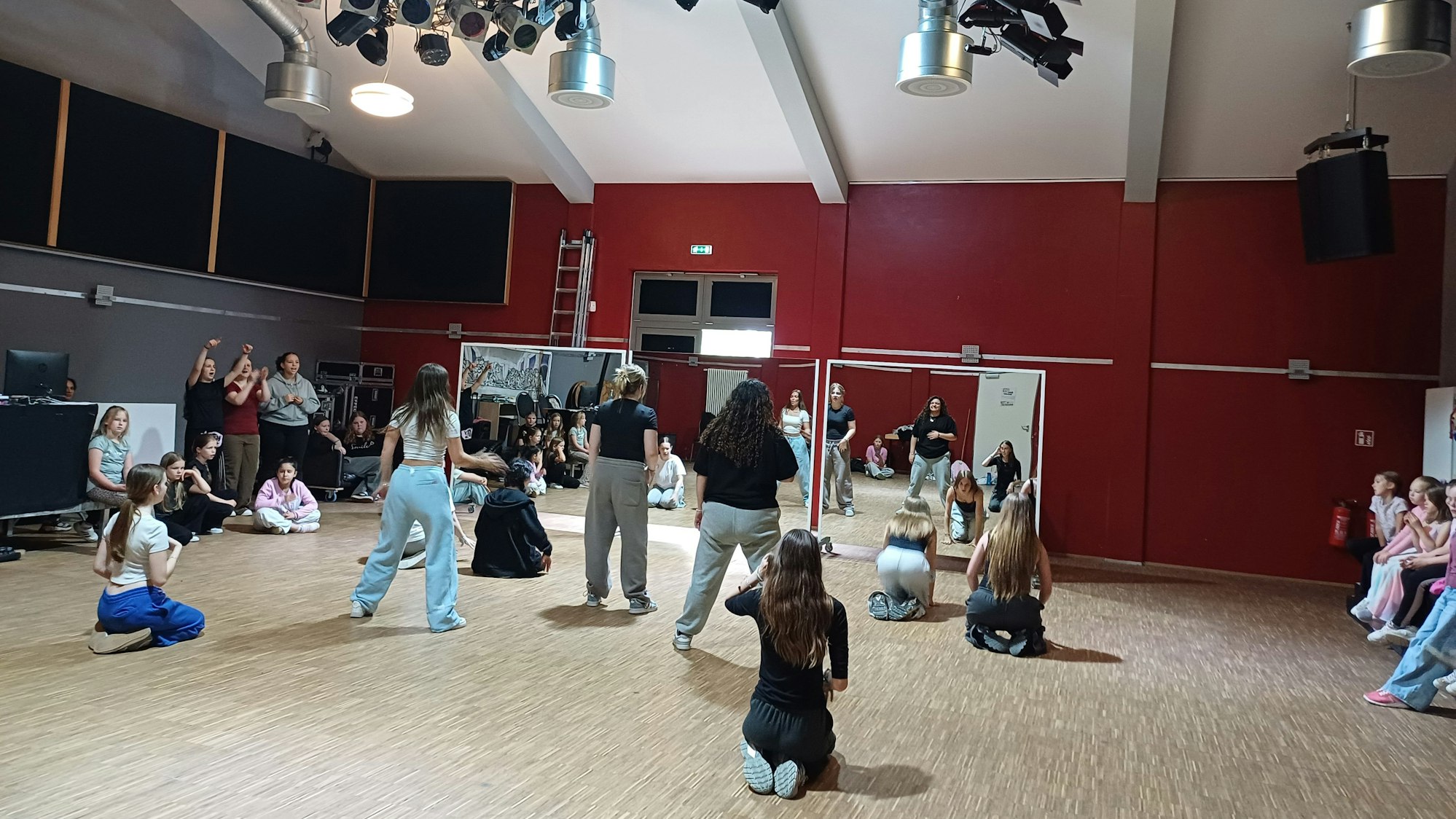 Kinder und Jugendliche bewegen sich in einem Tanzsaal.