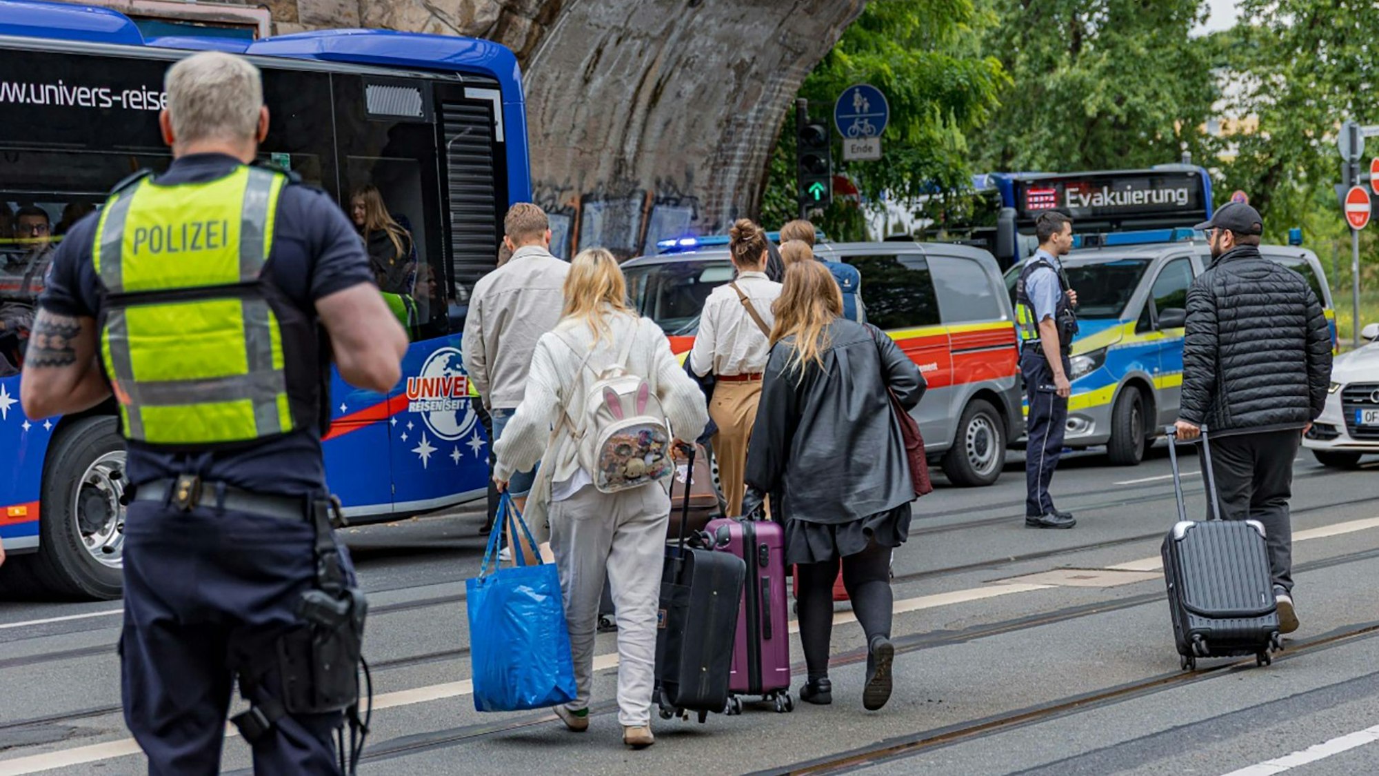 Fahrgäste eines liegengebliebenen ICE gehen nach teilweise über fünfstündiger Wartezeit im Zug an einer Eisenbahnunterführung am Bergischen Ring zu einem Bus.