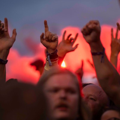 Das Bild zeigt mehrere in die Luft gehobenen Hände vor einem Sonnenuntergang.