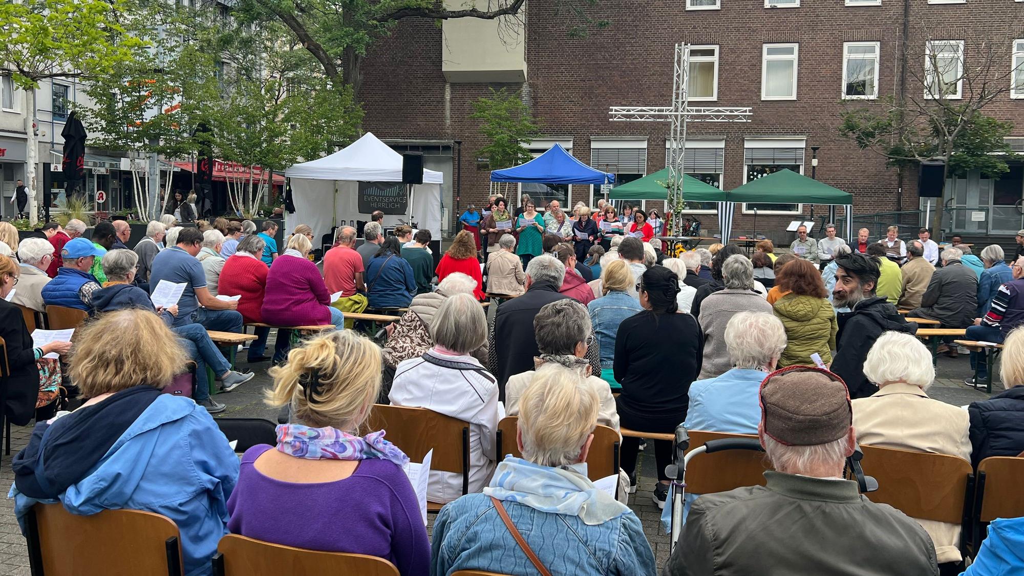 Menschen in Stuhlreihen auf dem Marktplatz