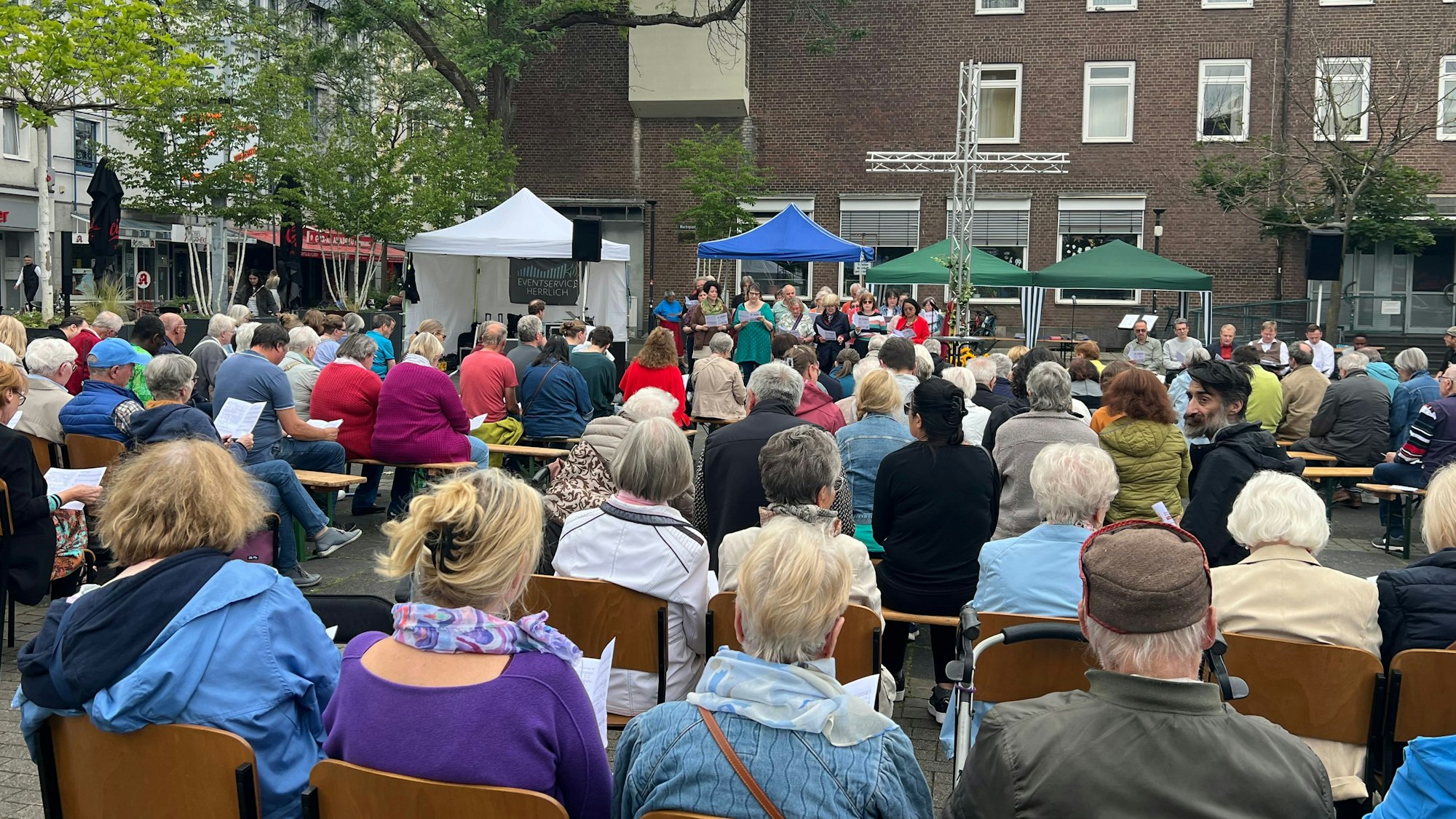 Menschen in Stuhlreihen auf dem Marktplatz