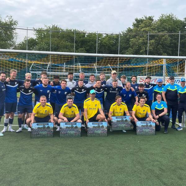 Vor der Mannschaft knieen die Spieler und der Trainer, die verabschiedet wurden.