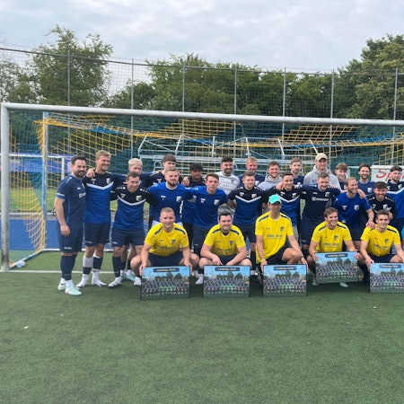 Vor der Mannschaft knieen die Spieler und der Trainer, die verabschiedet wurden.