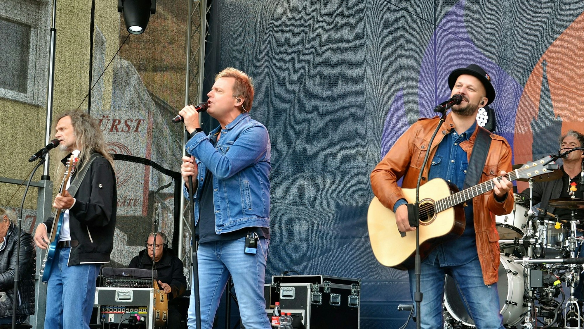 Die Kölner Kultband „Bläck Fööss“ spielt auf einer Bühne.