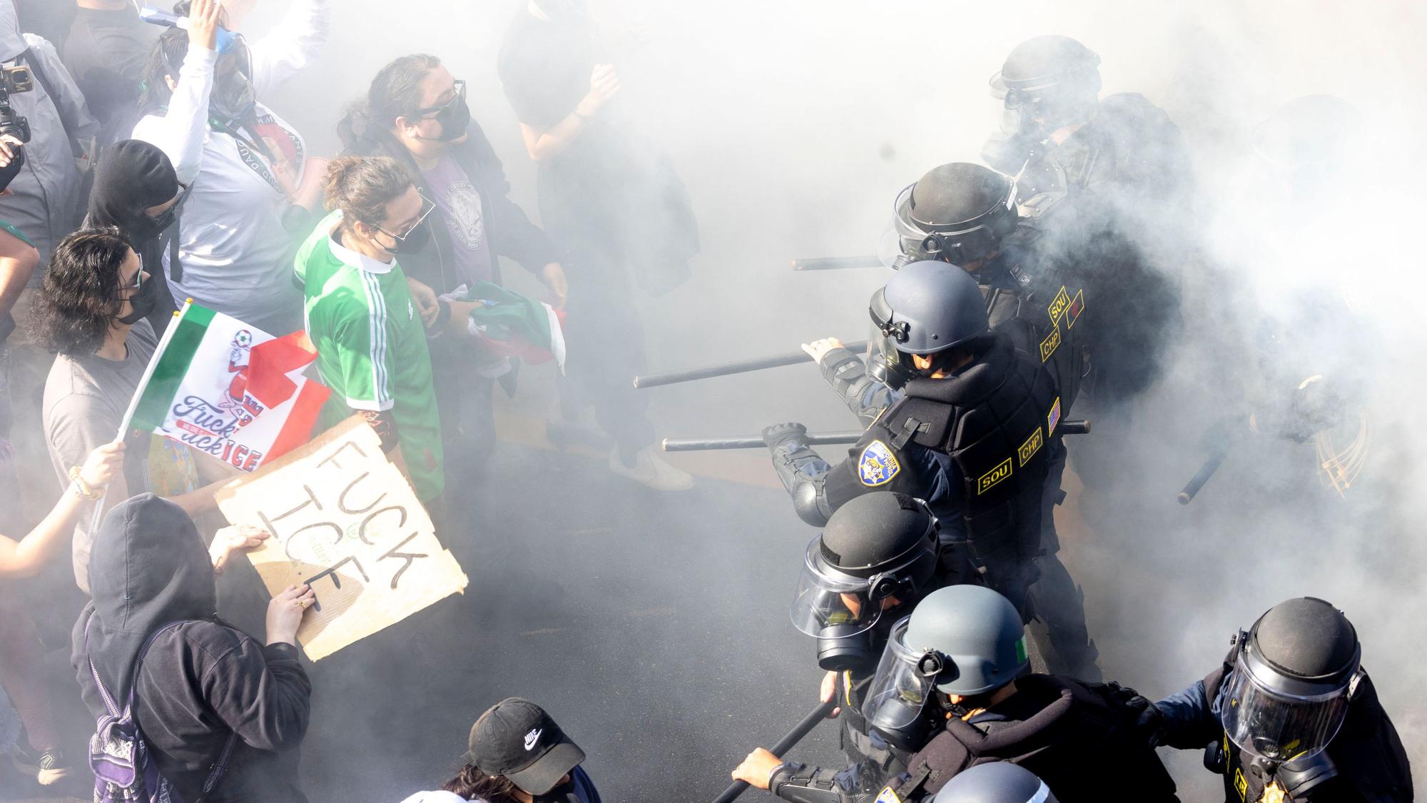 dpatopbilder - 08.06.2025, USA, Los Angeles: Rauch liegt in der Luft, als Demonstranten sich mit CHP-Beamten anlegen, nachdem sie den 101 Freeway in der Innenstadt besetzt haben, um gegen die Durchsuchung von Einwanderern zu protestieren. Foto: Jill Connelly/ZUMA Press Wire/dpa +++ dpa-Bildfunk +++