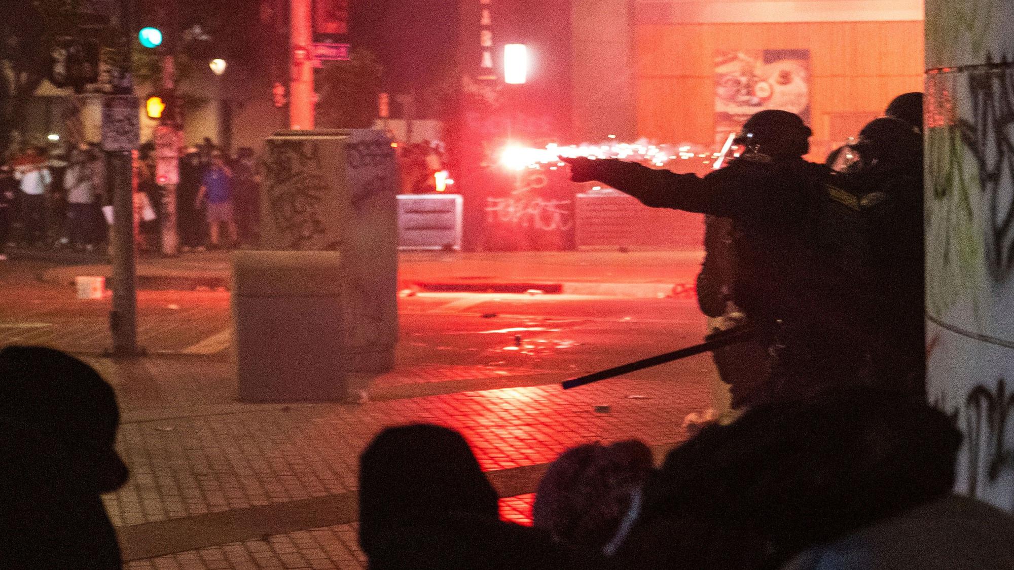09.06.2025, USA, Los Angeles: Polizisten gehen während der Proteste gegen die Razzien der Trump-Regierung gegen Einwanderer in Los Angeles vor Geschossen in Deckung. Foto: Ethan Swope/FR171736 AP/dpa +++ dpa-Bildfunk +++