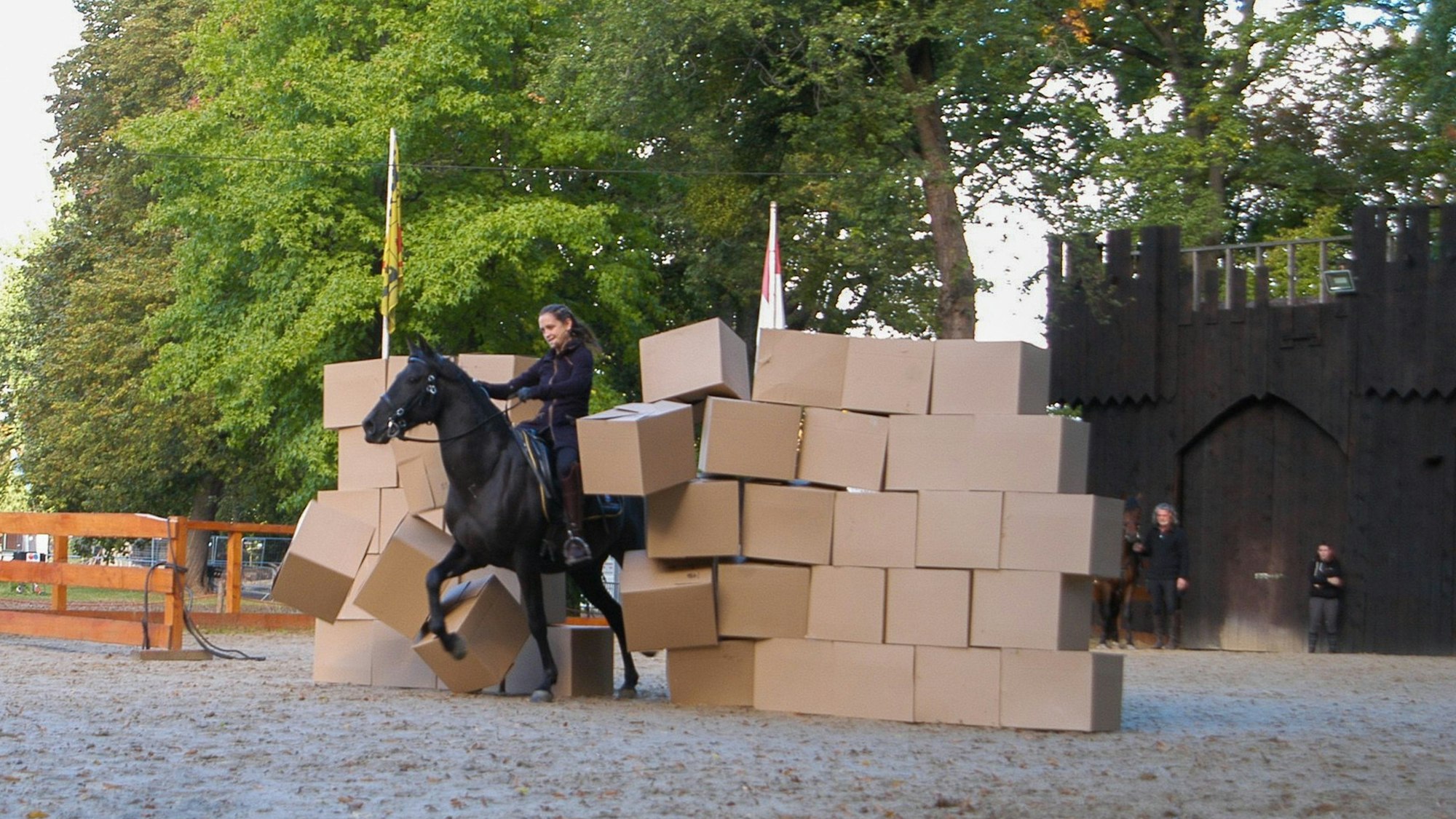 Patricia Gräfin Beissel reitet durch eine Wand aus Kartons.
