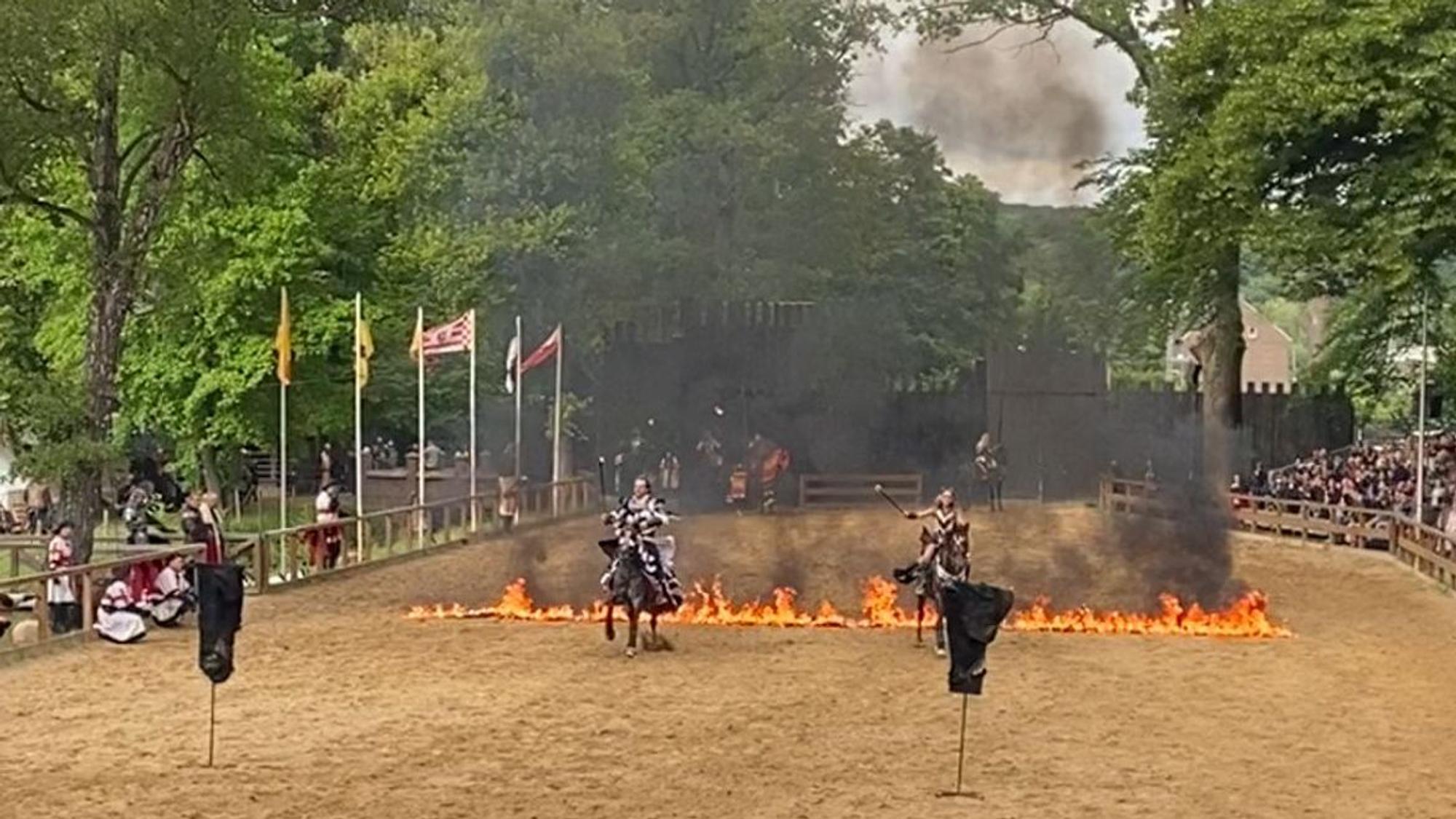 Zwei Ritter reiten durch eine Linie aus Feuer.