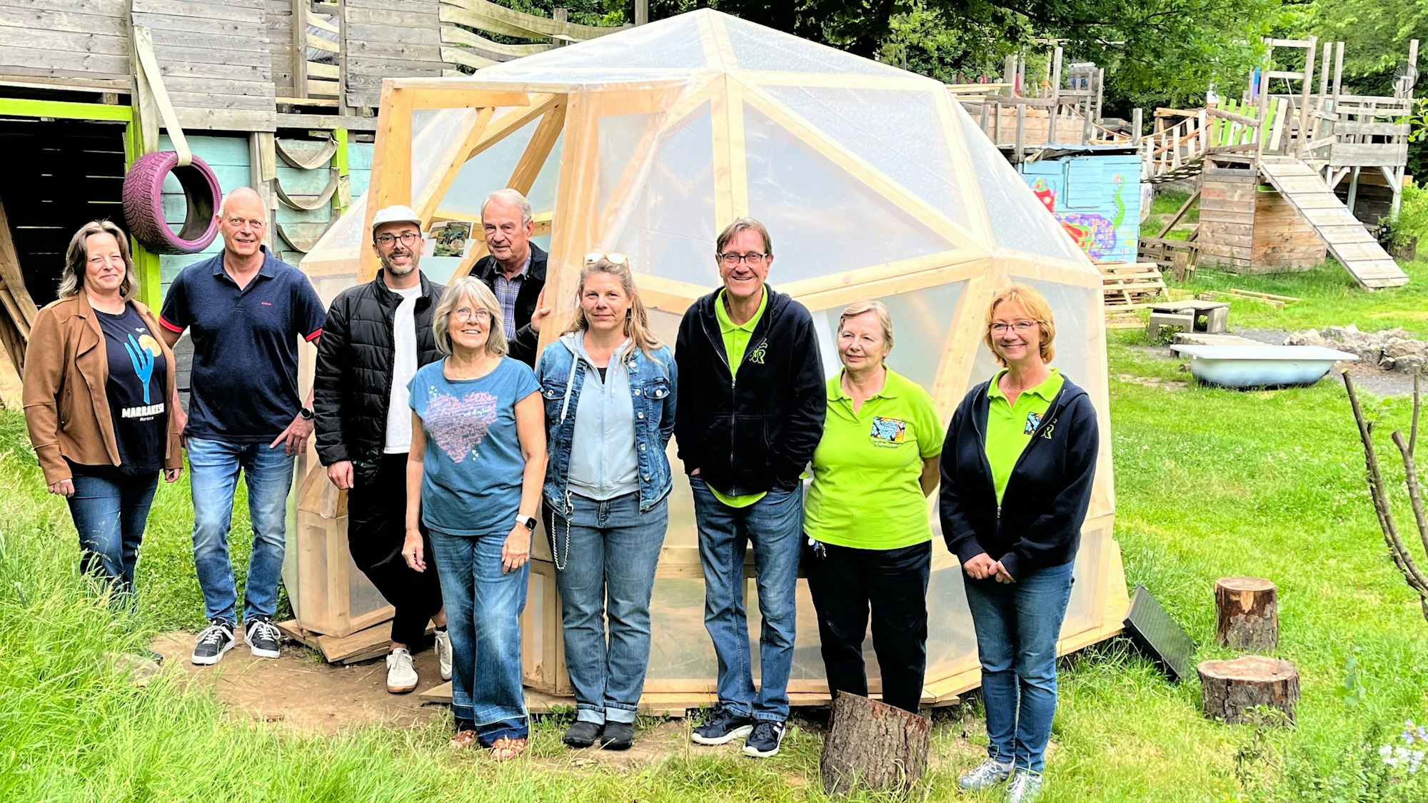 Neun Menschen stehen vor einem neuen Geodom.