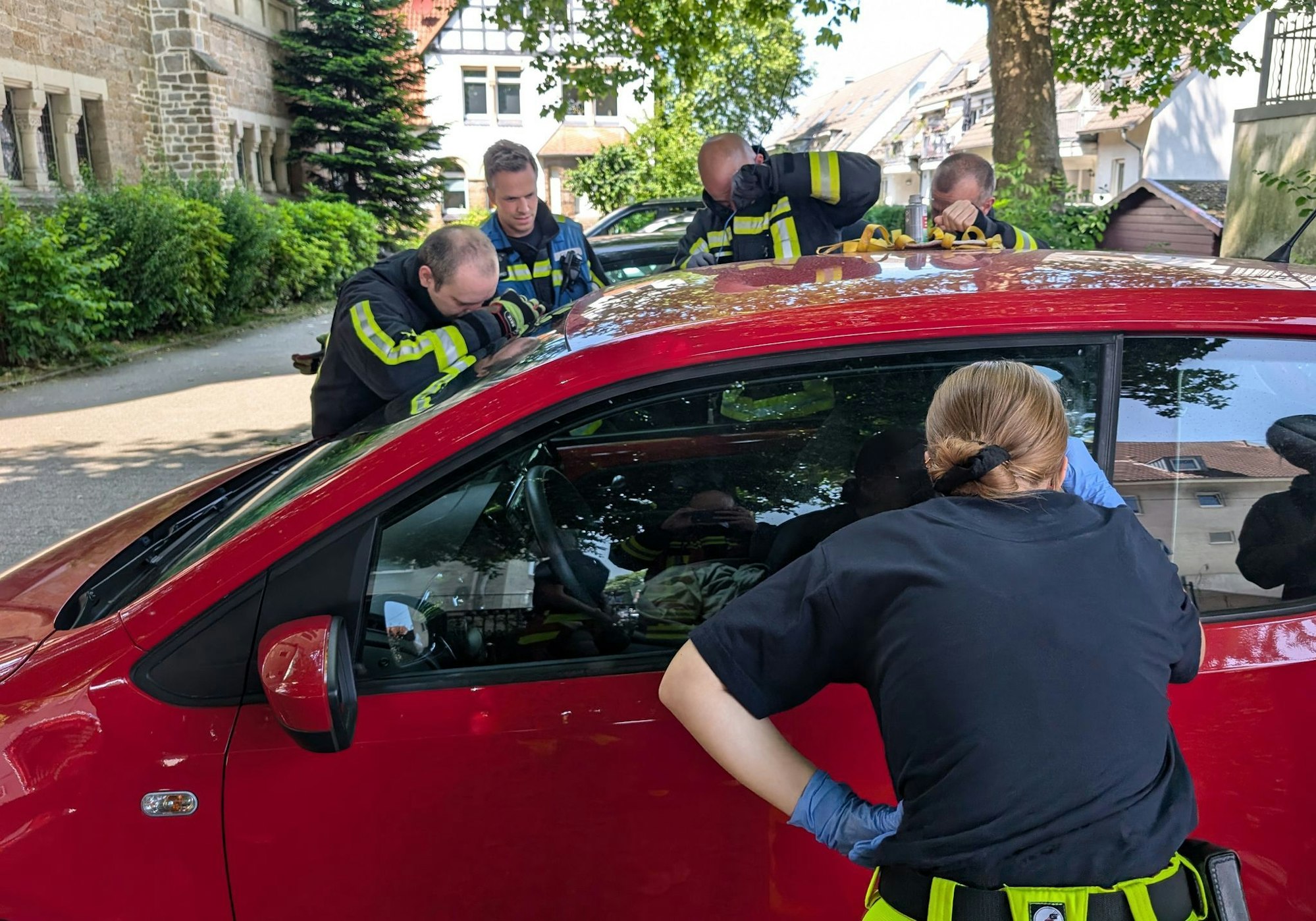 Feuerwehrleute schauen nach, wie es dem Mädchen in dem Auto geht. Es war bester Laune.