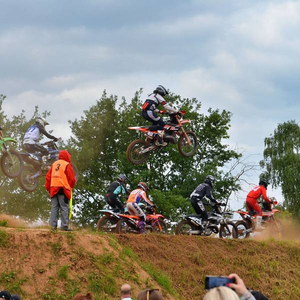 Motocross-Fahrer verlassen teil springend einen Hügel.