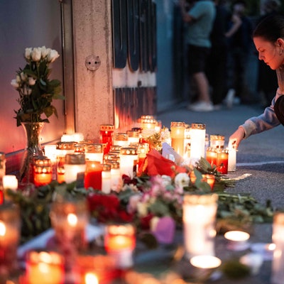 Eine Frau zündet eine Kerze im Gedenken an die Todesopfer des Amoklaufs vom Graz am 10. Juni 2025 an. Foto: Georg Hochmuth / AF