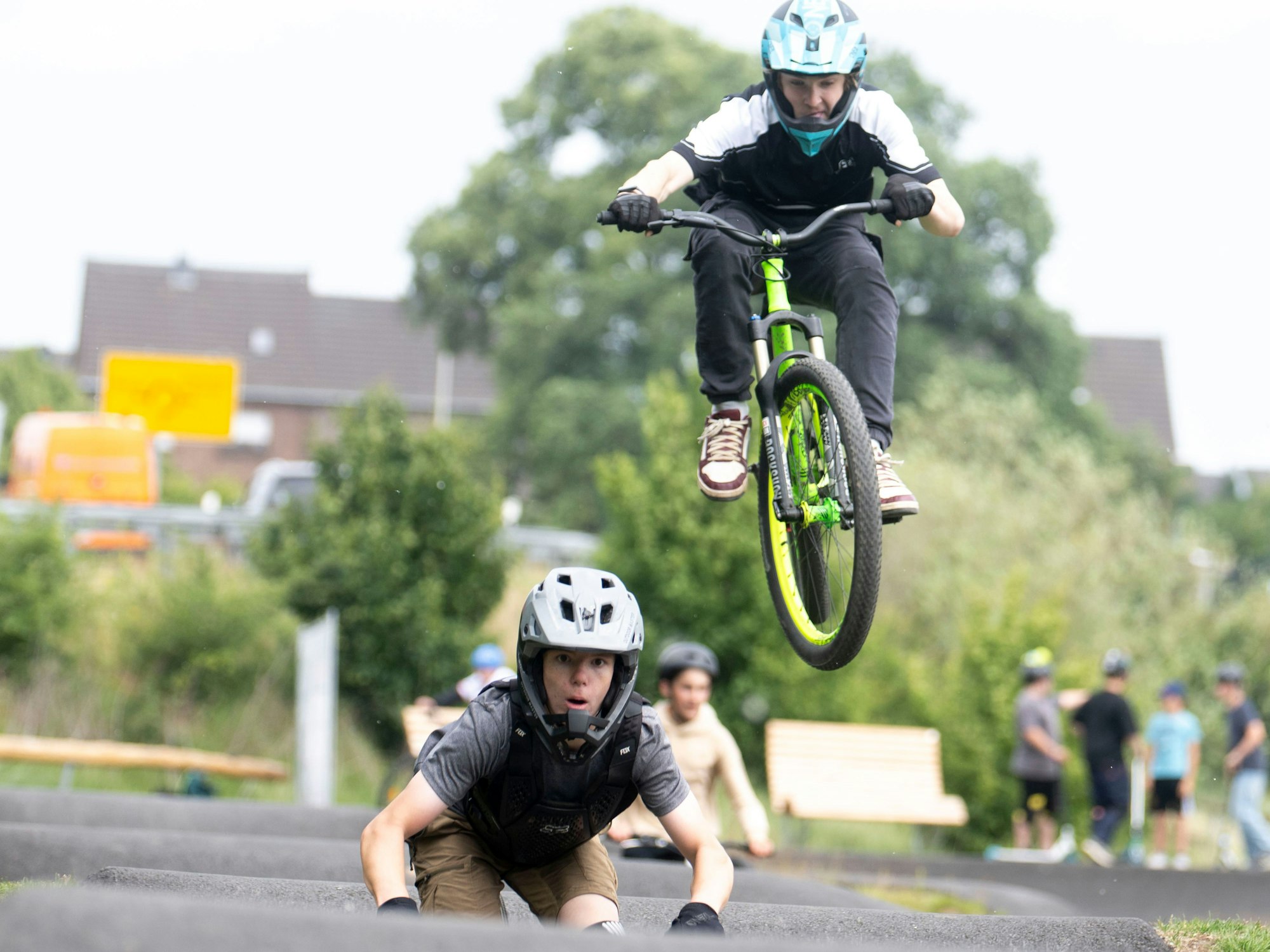 Ein Radfahrer springt über einen Hügel des Pumptracks in Weilerswist. Dahinter kommt direkt ein nächster angefahren.