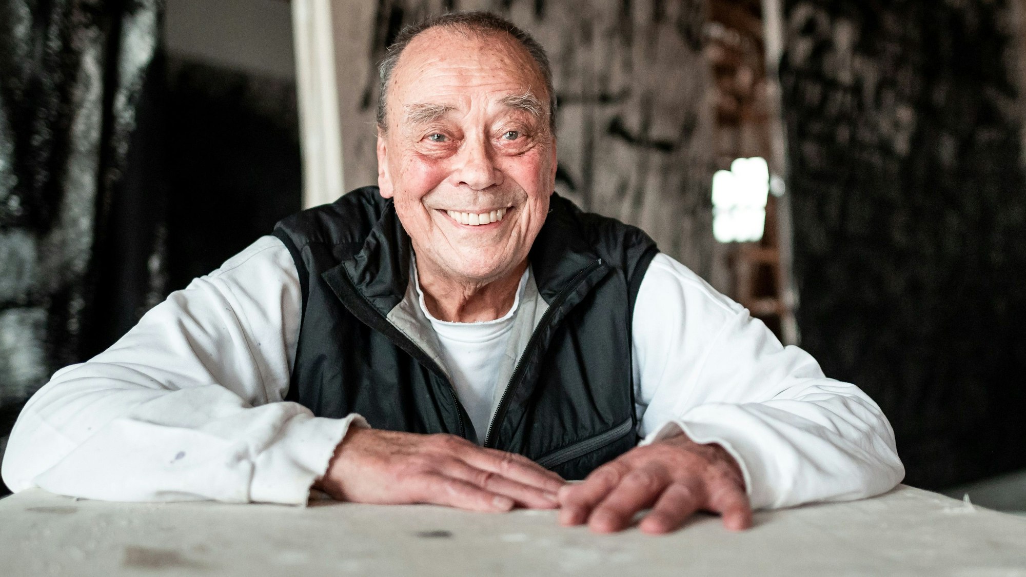 Der Künstler und Maler Günther Uecker sitzt lachend in seinem Atelier. Uecker starb am 10.06.2025 im Alter von 95 Jahren.