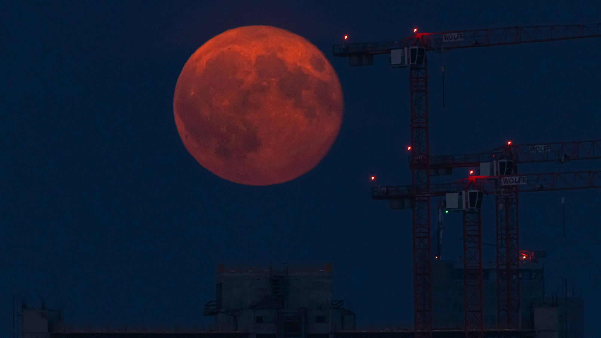 Ein besonders tief stehender Vollmond über einer Baustelle (Archivfoto).