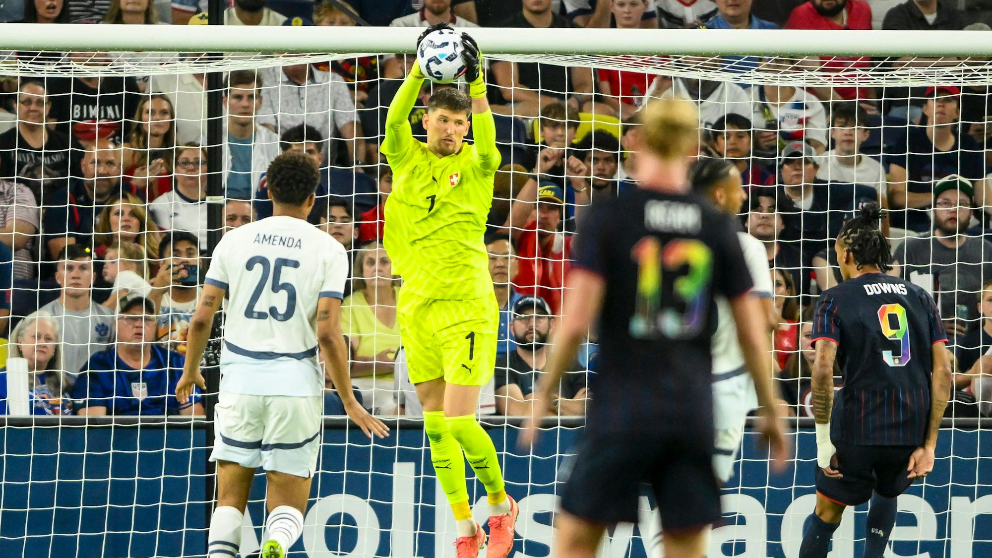 Gregor Kobel fängt hoch in der Luft einen Ball, während Damion Downs auf ihn zuläuft.