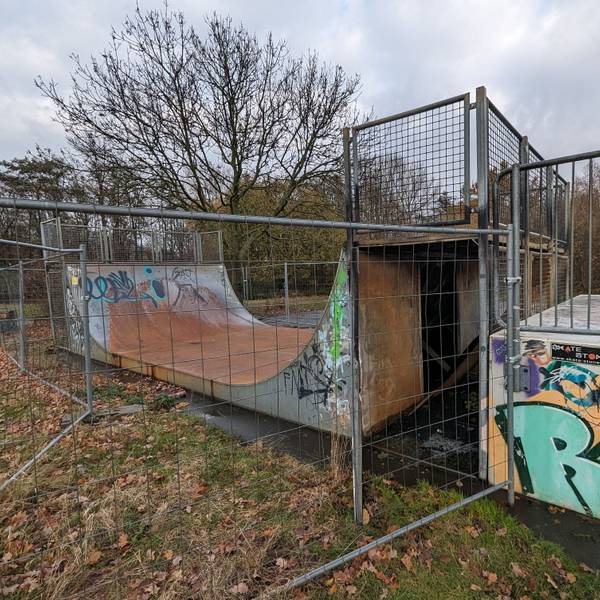 Das Foto zeigt die zerstörte Halfpipe hinter einem Bauzaun.