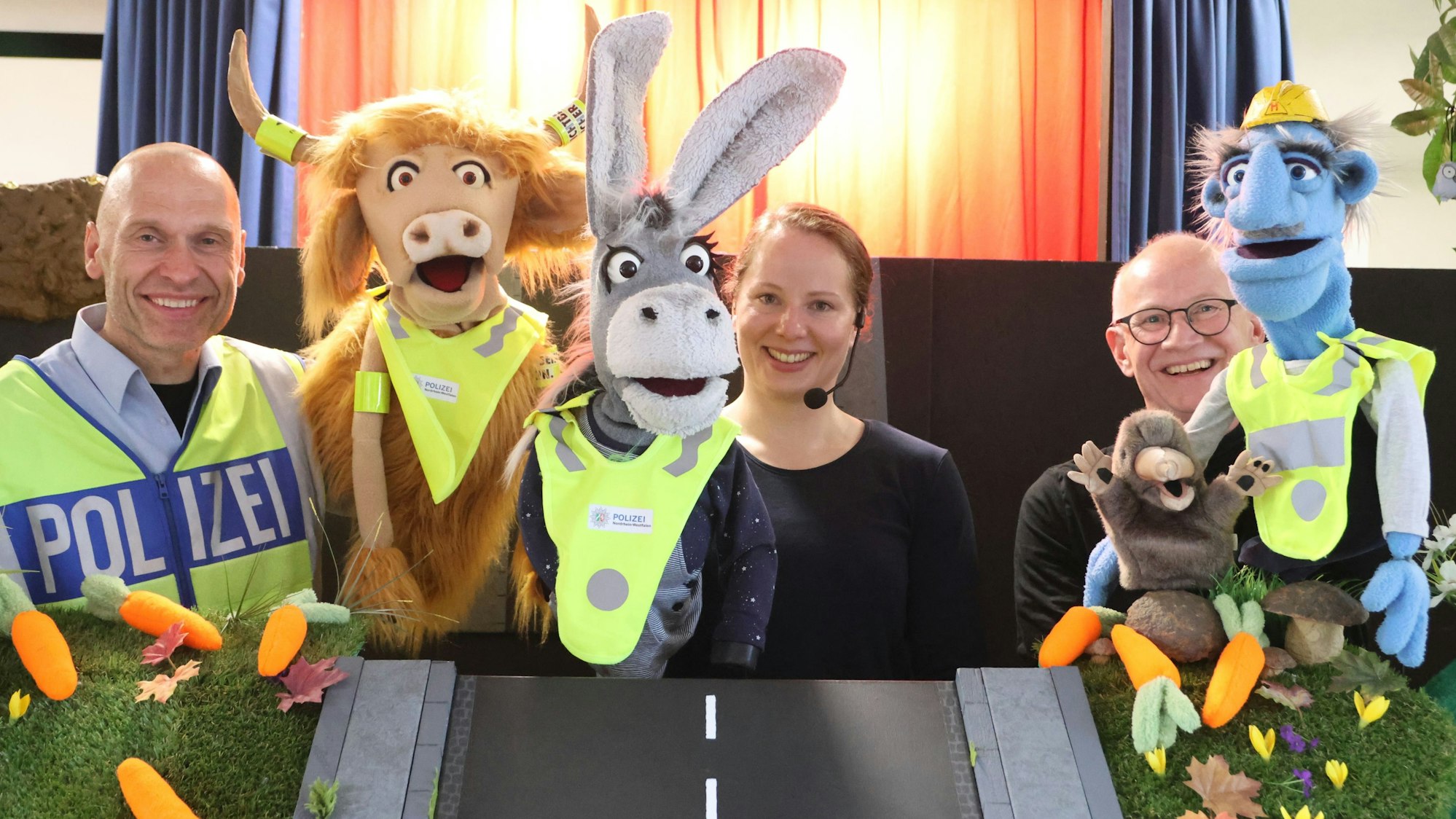 Ansgar Schubert, Tina Bors und Jürgen Luzar erklären mit ihren Puppen, wie man eine Straße überquert.