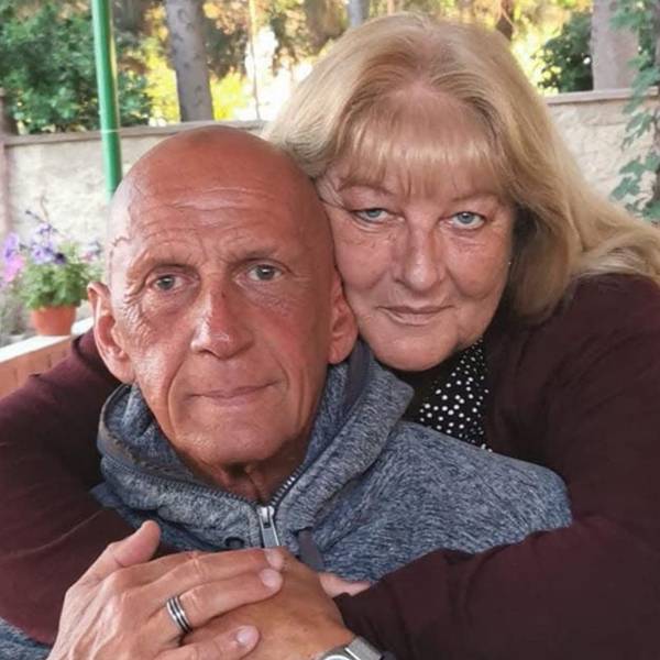 Auf dem Bild sind ein Mann und eine Frau zu sehen, die Frau legt die Arme um den Mann.