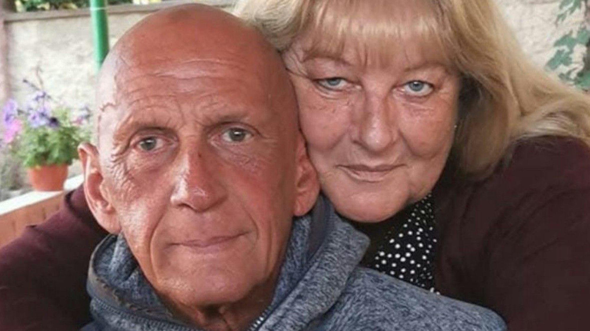 Auf dem Bild sind ein Mann und eine Frau zu sehen, die Frau legt die Arme um den Mann.