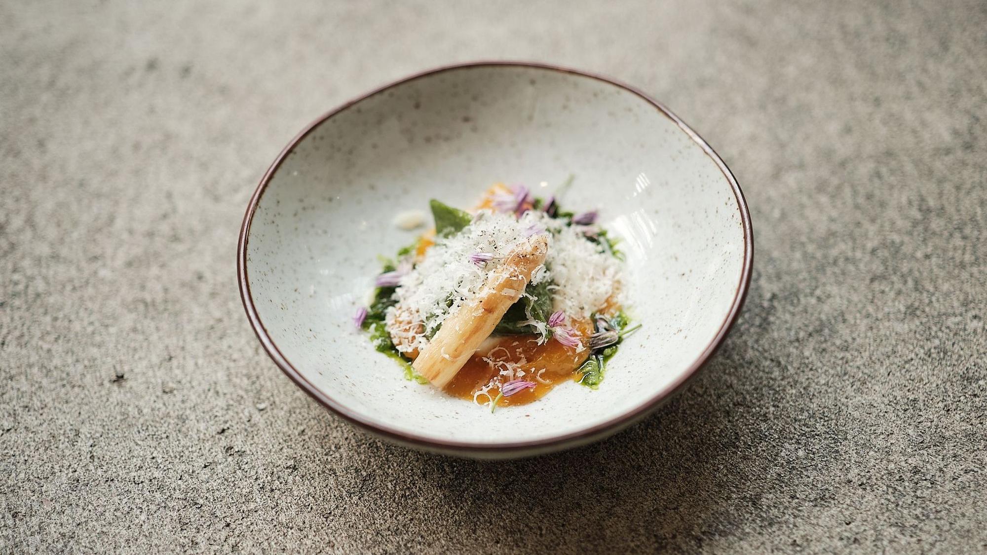Ein Gang, hübsch angerichtet mit Blüten und Kräutern, aus einem Top-Restaurant.