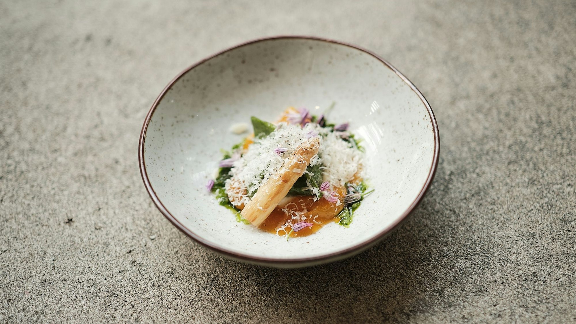 Ein Gang, hübsch angerichtet mit Blüten und Kräutern, aus einem Top-Restaurant.