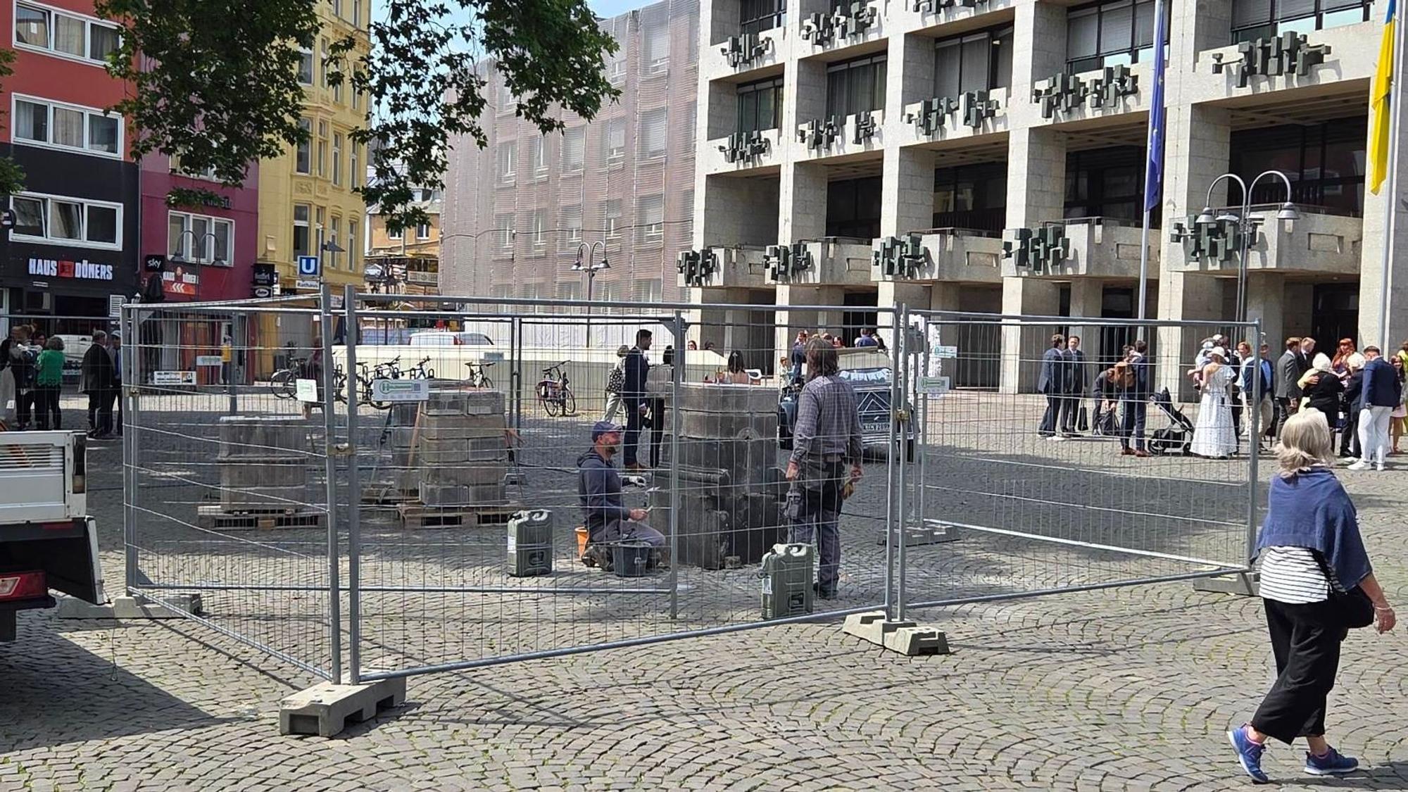 Mitarbeiter eines Steinmetzbetriebs bauen die Wasserpumpe am Alter Markt auf.