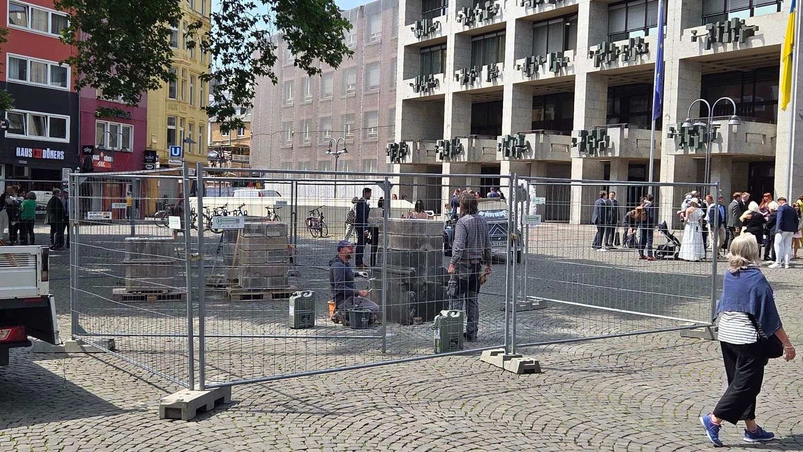 Mitarbeiter eines Steinmetzbetriebs bauen die Wasserpumpe am Alter Markt auf.