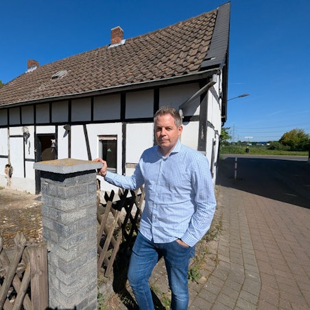 Das Foto zeigt den Sohn der Eigentümerin vor dem kleinen Fachwerkhaus in Sielsdorf.