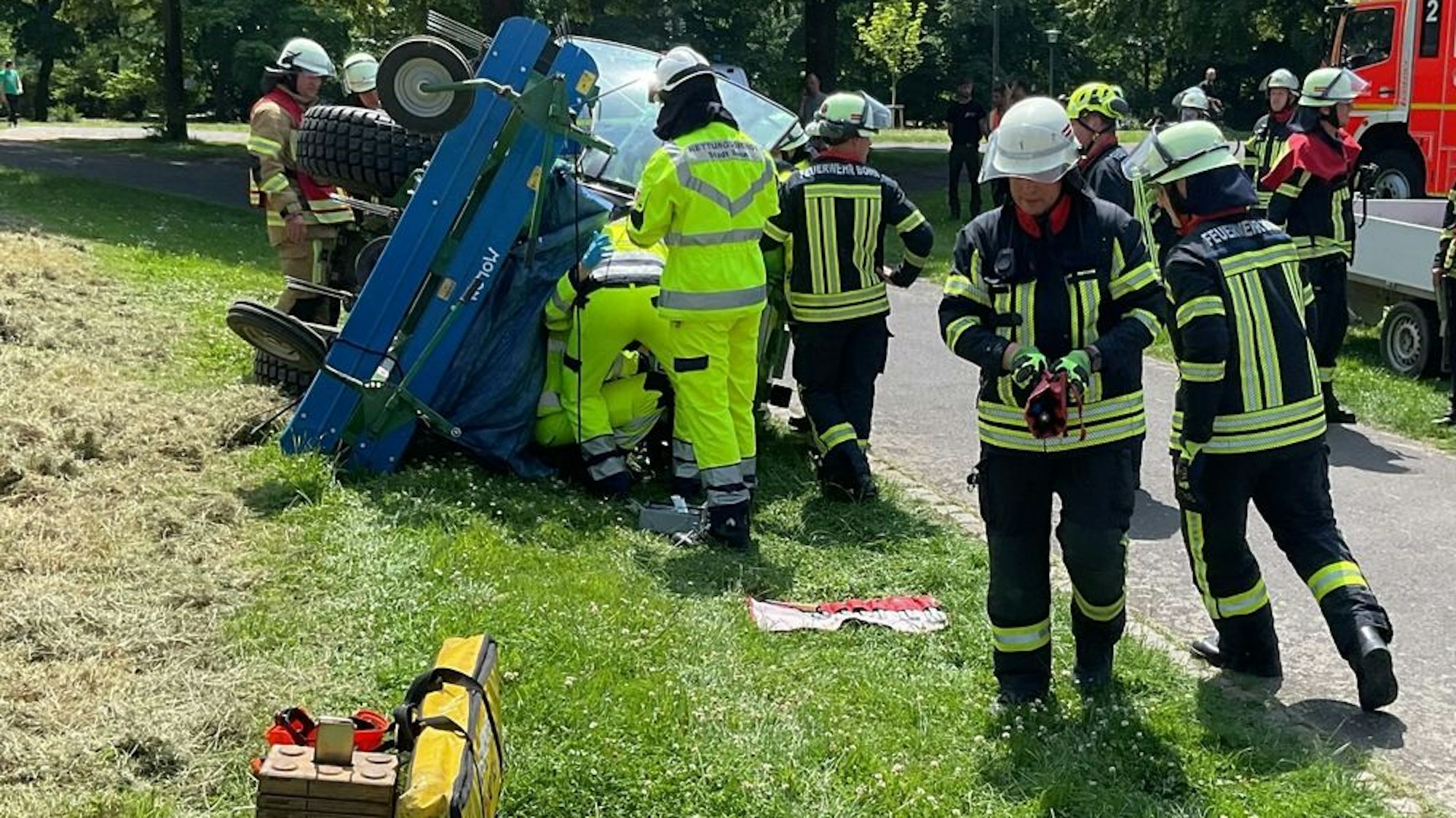 Arbeitsunfall in der Beueler Rheinaue - Ein Arbeiter wurde unter einem umgestürzten Traktor eingeklemmt und musste von der Feuerwehr befreit werden.