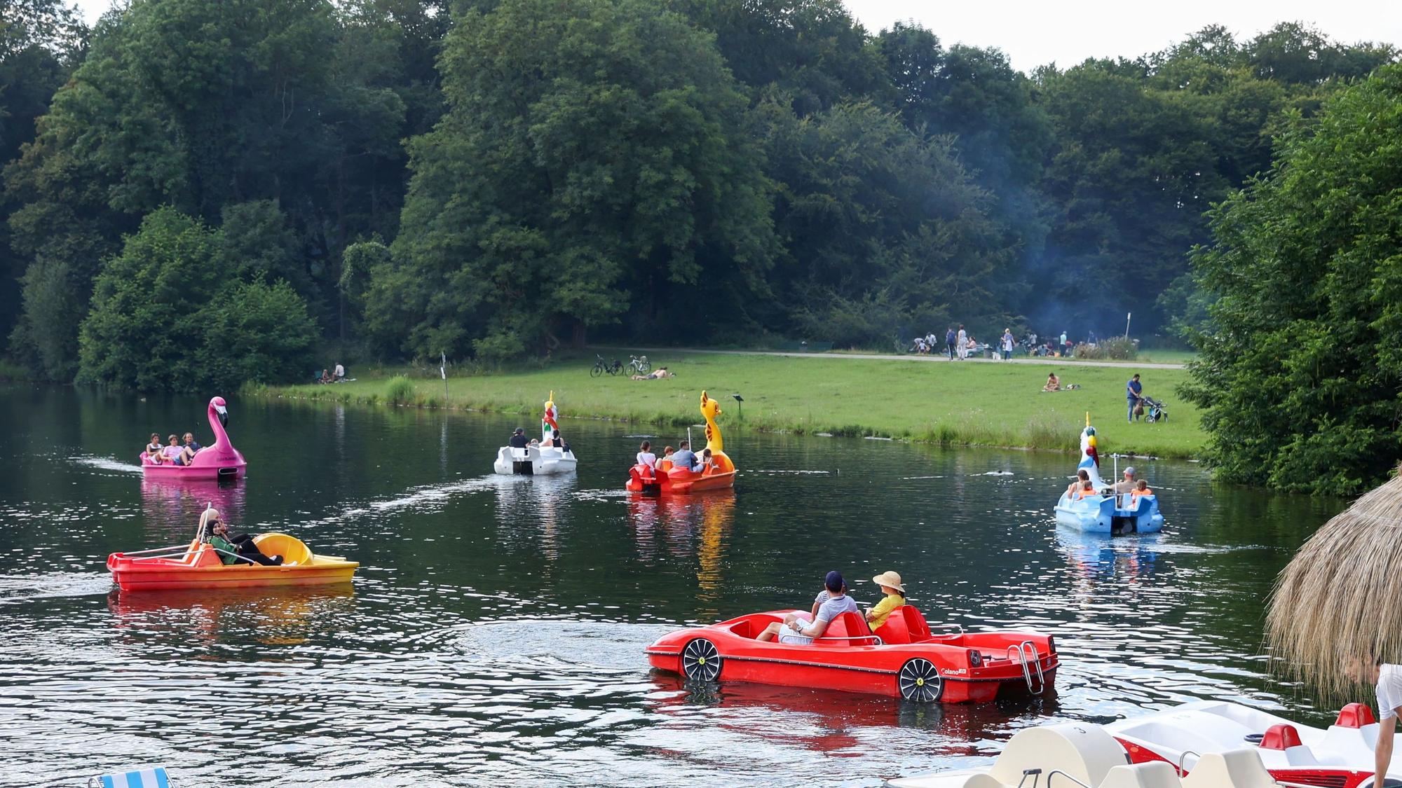Besucher fahren Tretboot am Decksteiner Weiher.
Die Boote habe lustige Formen:
Einhorn, Sportwagen, Flamingo etc. (Archivbild)