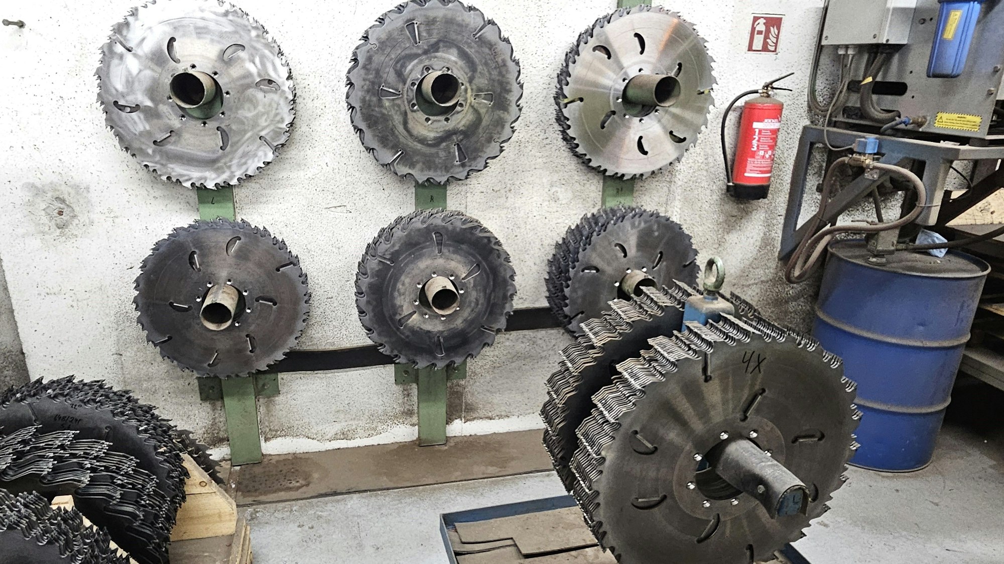 Verschiedene Sägeblätter hängen an der Wand oder an einem Ständer.