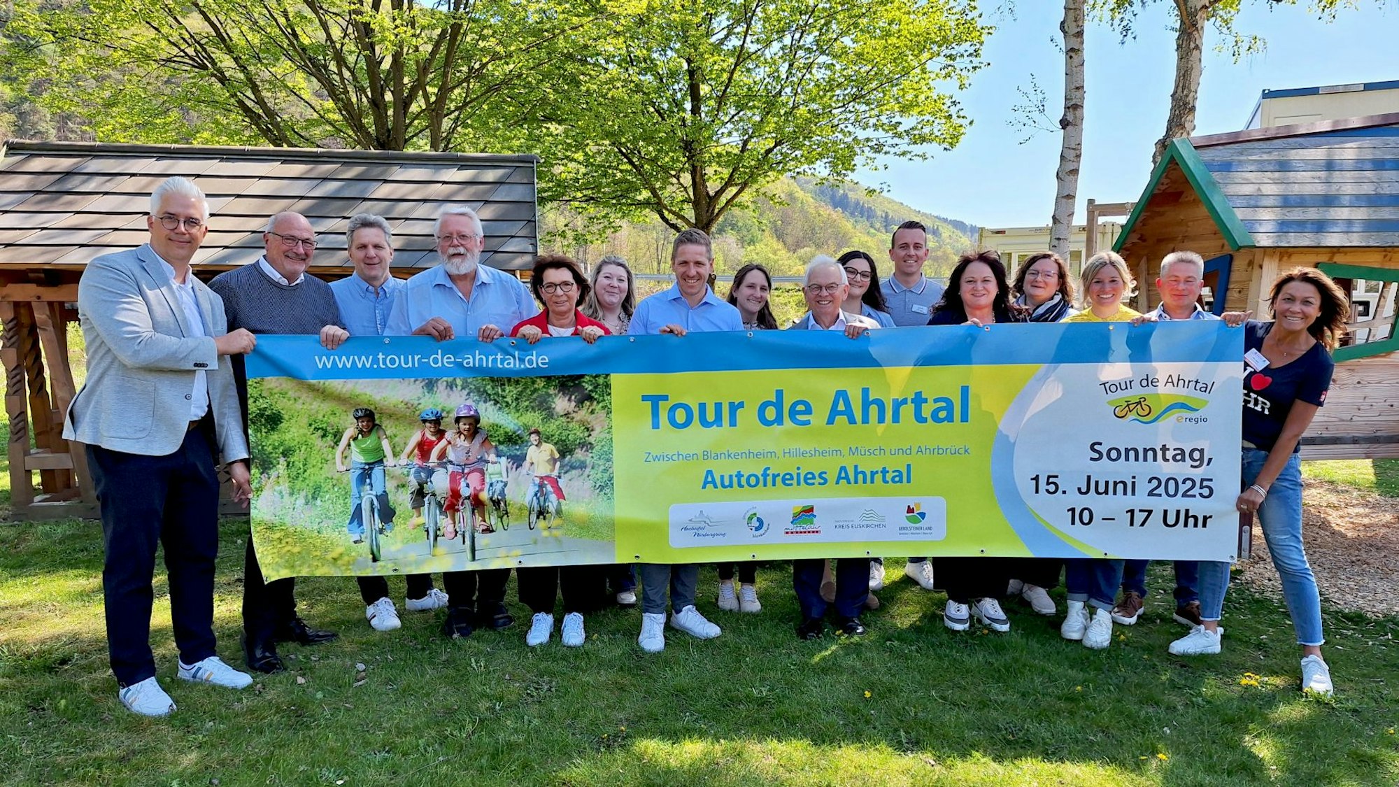Mehrere Vertreter aus den beteiligten Kommunen und der Sponsoren halten das Veranstaltungsbanner zur 19. „Tour de Ahrtal“ ins Bild.