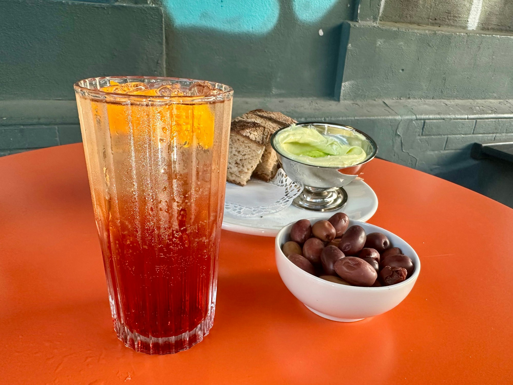 Ein Glas und Teller stehen auf einem roten Tisch