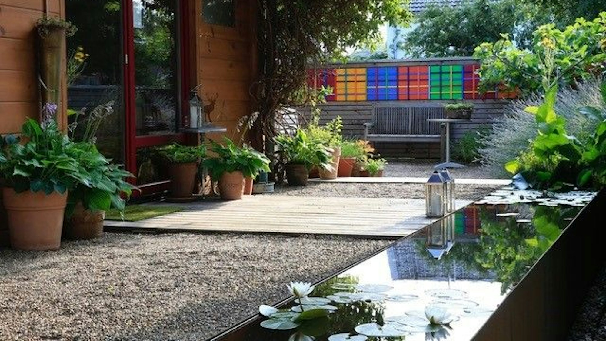 Eine Terrasse bestehend aus Kies und Holz gehört mit zum Garten.