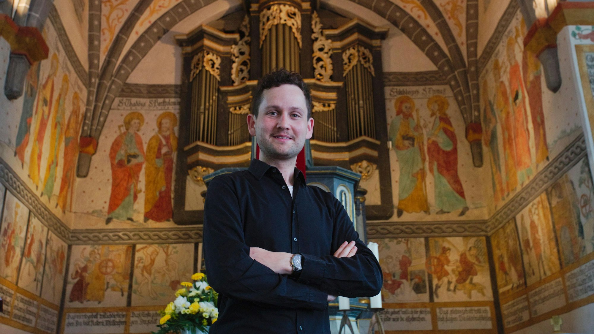 Ein junger Mann vor der Orgelempore.
