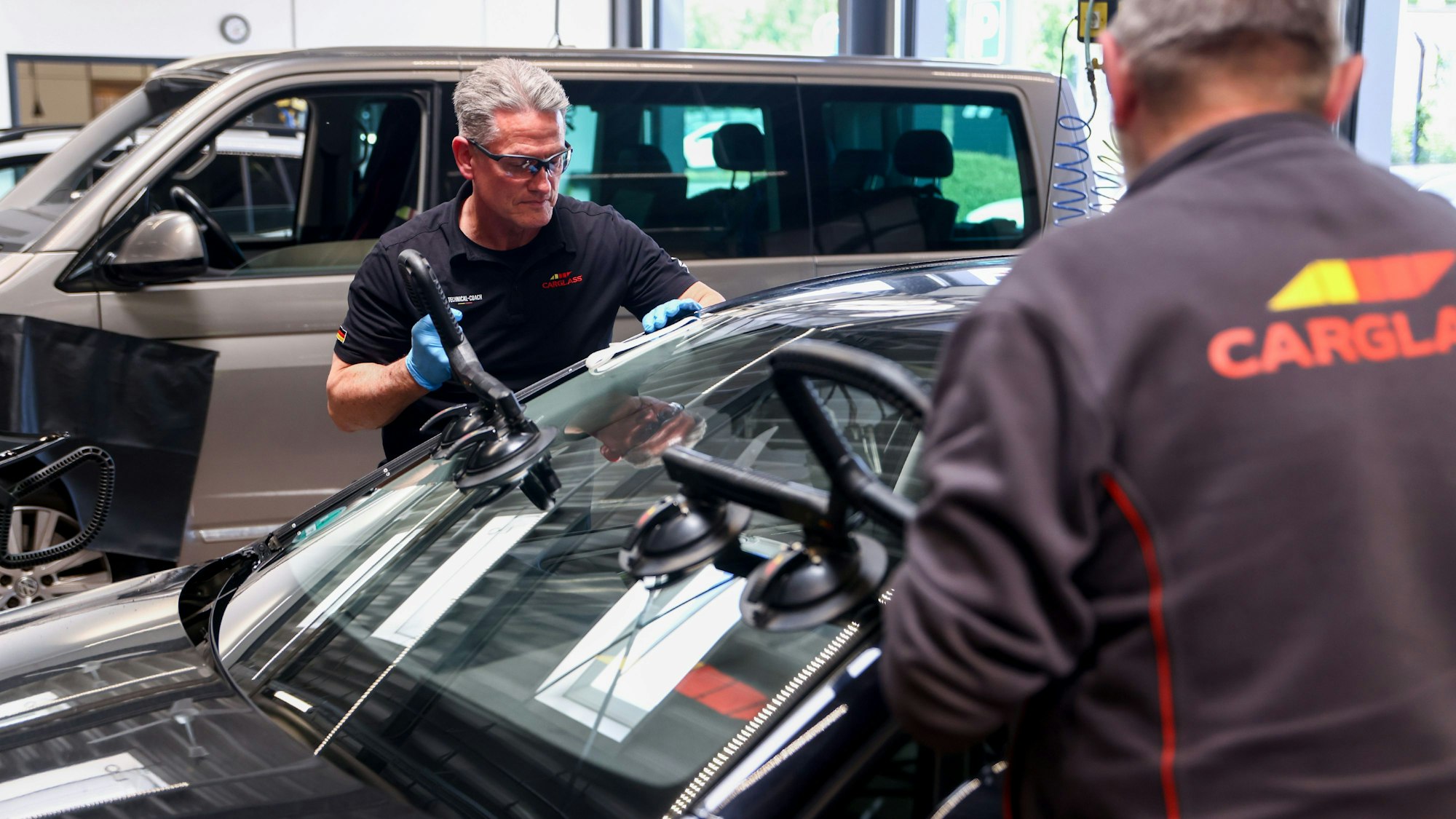 Technical Coach Andreas Vieth setzt mit einem Kollegen eine Scheibe ein.