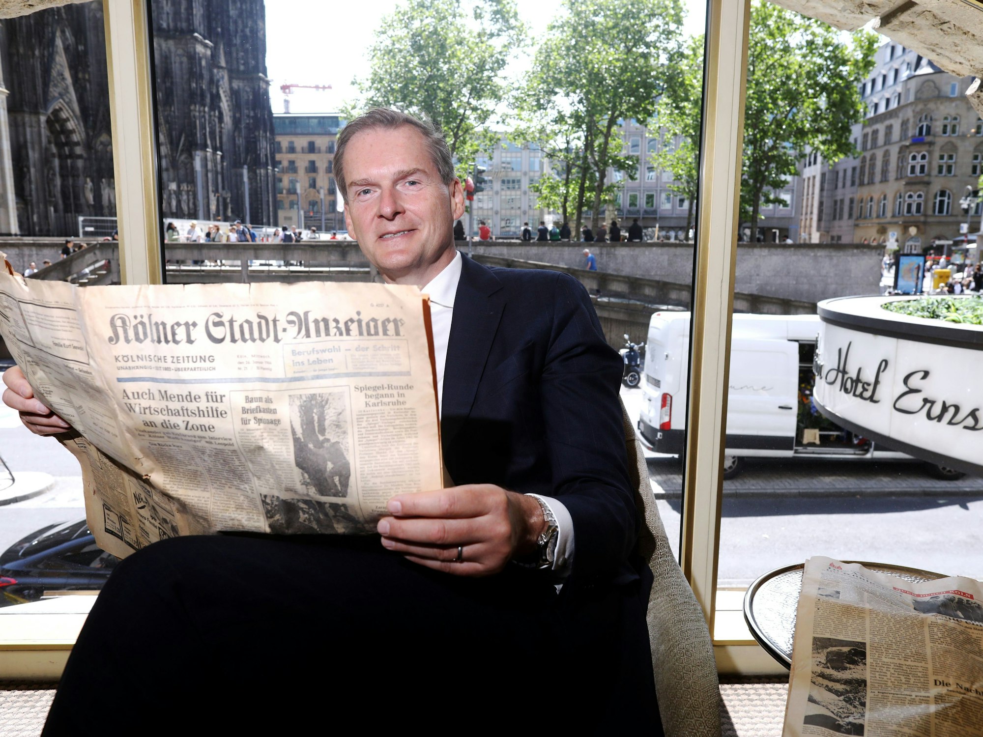 12.06.2025, Köln: Hotel Direktor Georg Plesser durchstöbert die alte Ausgabe des Kölner Stadt-Anzeigers von 1966. Bei der Renovierung von Zimmern im Excelsior-Hotel wurde ein unversehrter Stadt-Anzeiger von 1966 gefunden. Foto: Arton Krasniqi